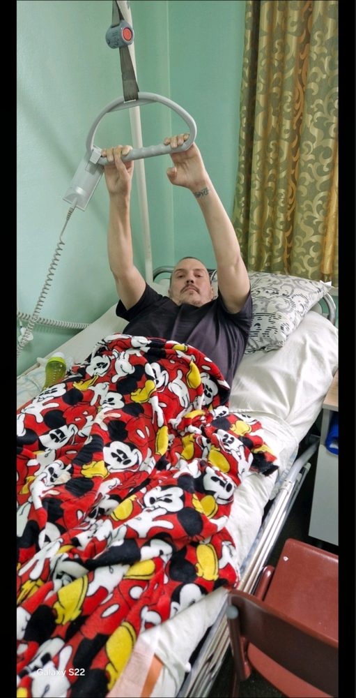 Олексій виконує реабілітаційну вправу на лікарняному ліжку після операції